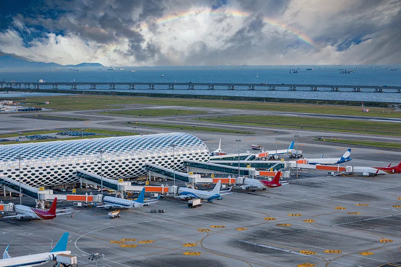 Panoramic view of Shenzhen Bao'an International Airport terminal with aircraft on the apron by the coast