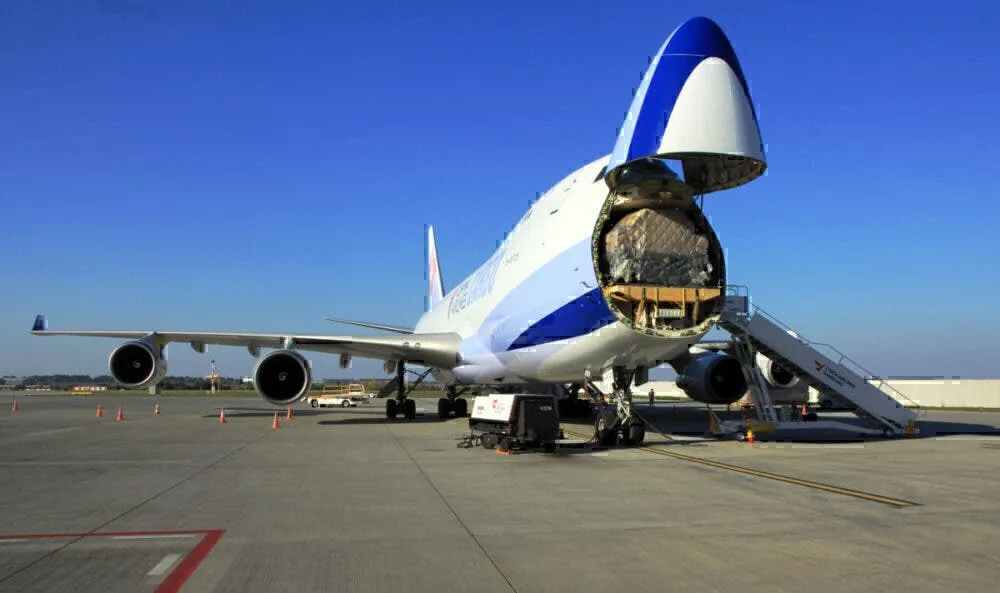 Boeing 747 freighter with nose door lifted, loading ULD pallets of cargo