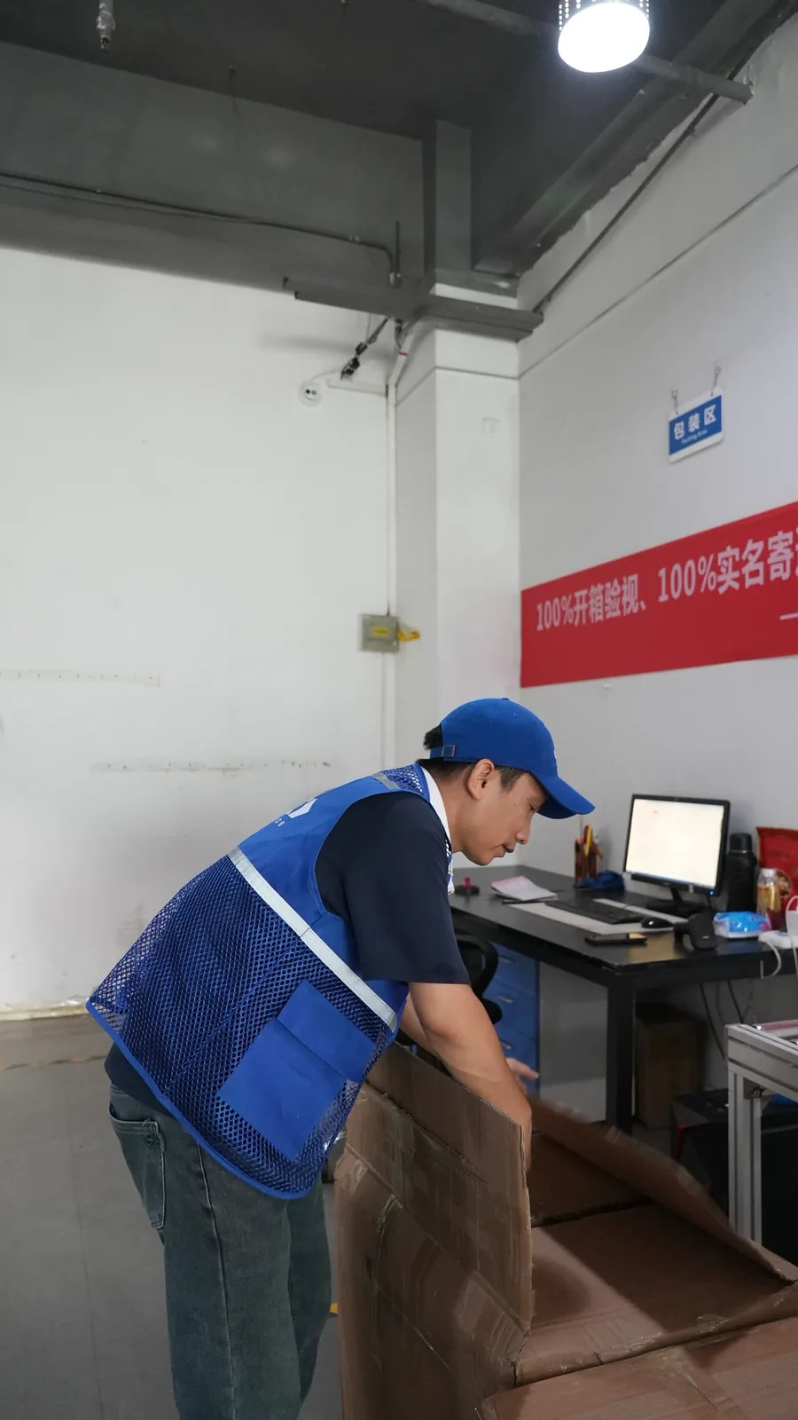 Warehouse operator processing cargo information and waybill data at workbench